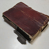 This image showcases an antique book in a deteriorated state before restoration, with its cracked and peeling red leather cover, detached spine, and fragile binding. A prime example of book conservation needs, this "before" photo highlights the effects of time and wear, setting the stage for an expert restoration to preserve its historical and sentimental value.