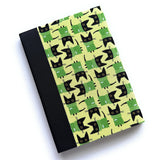 The Kuro Neko keepsake card features a playful pattern of black cats wearing green sweaters on a soft yellow background. Paired with a sleek black book cloth spine, this handcrafted card is perfect for cat lovers, adding a touch of charm and whimsy to heartfelt messages and cherished notes.