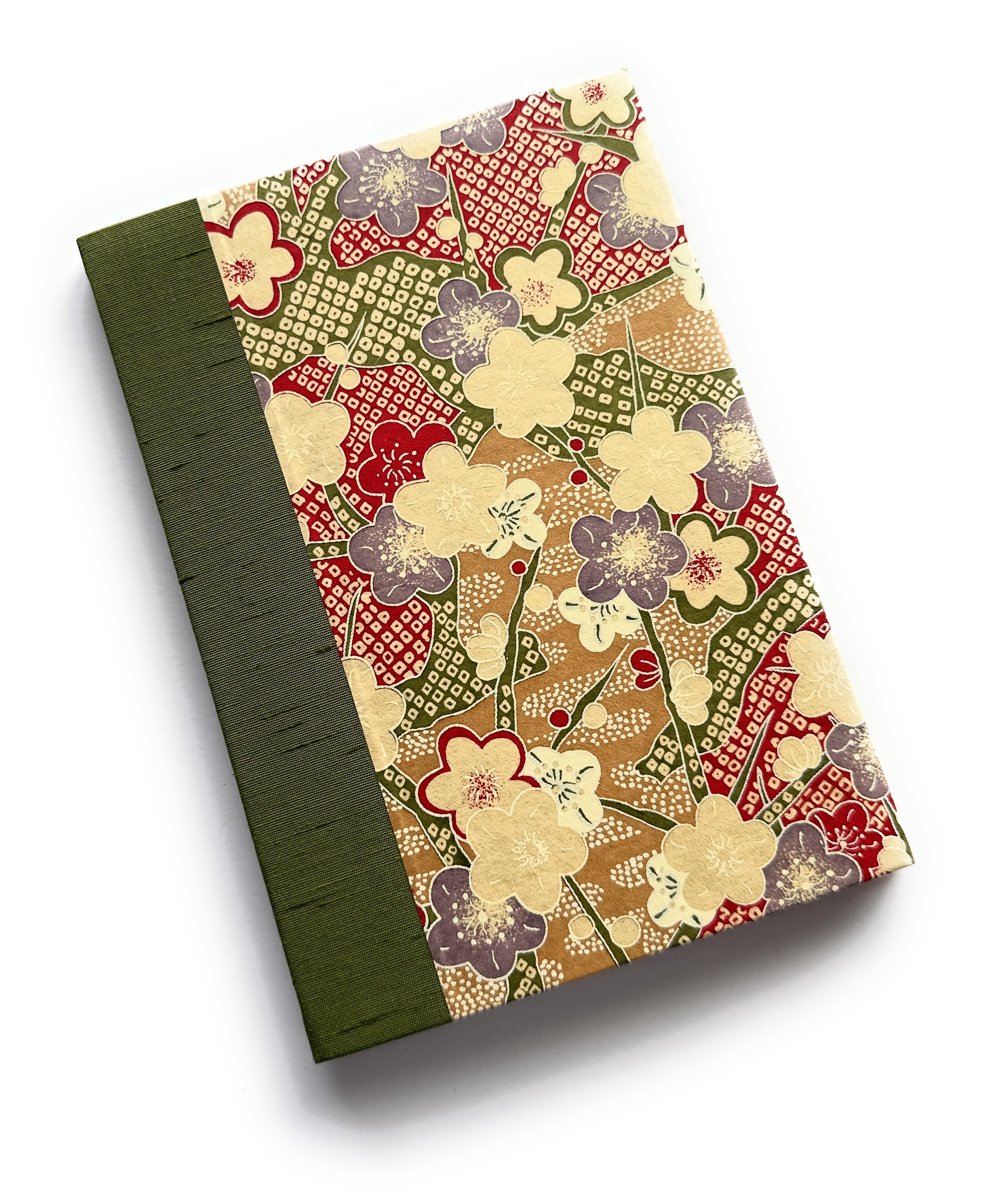 The Ume No Hana keepsake card features a stunning Japanese-inspired plum blossom pattern in red, beige, and purple hues. Handcrafted with a rich green book cloth spine, this elegant card is perfect for heartfelt messages, special occasions, and treasured memories.