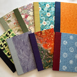 A collection of handmade keepsake cards featuring a variety of elegant fabric covers, including floral patterns, abstract designs, and playful cat motifs. Each card is carefully crafted with high-quality materials, making them perfect for meaningful messages, special occasions, or heartfelt gifts.