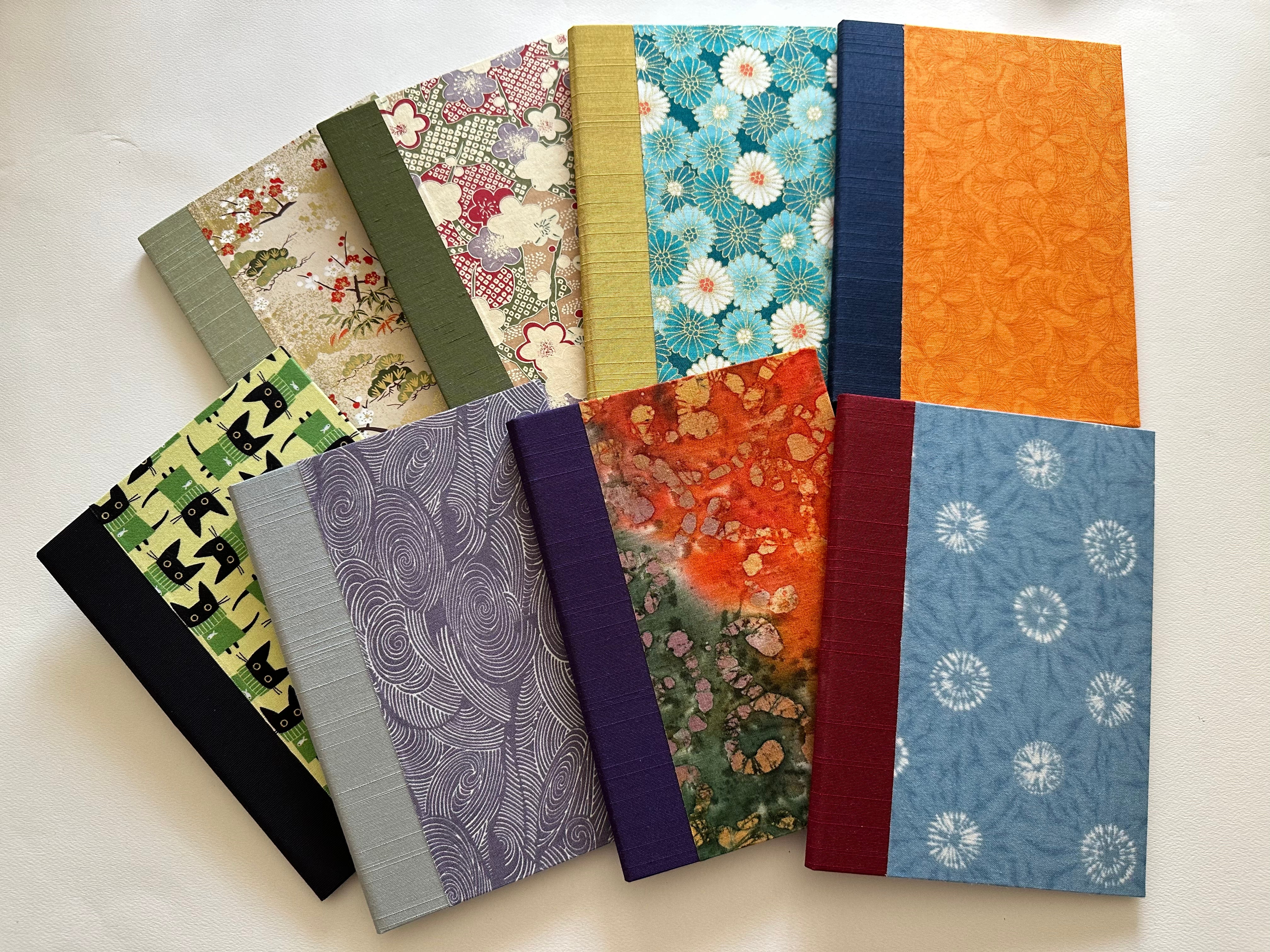 A collection of handmade keepsake cards featuring a variety of elegant fabric covers, including floral patterns, abstract designs, and playful cat motifs. Each card is carefully crafted with high-quality materials, making them perfect for meaningful messages, special occasions, or heartfelt gifts.