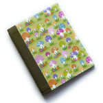 The Merry Mushroom DIY Bookmaking Kit features a whimsical, colorful mushroom pattern on a vibrant green background, accented with playful florals. This handmade bookbinding kit includes all the necessary materials to create a unique journal, perfect for nature lovers, fantasy enthusiasts, and those who appreciate fun, botanical-inspired stationery.