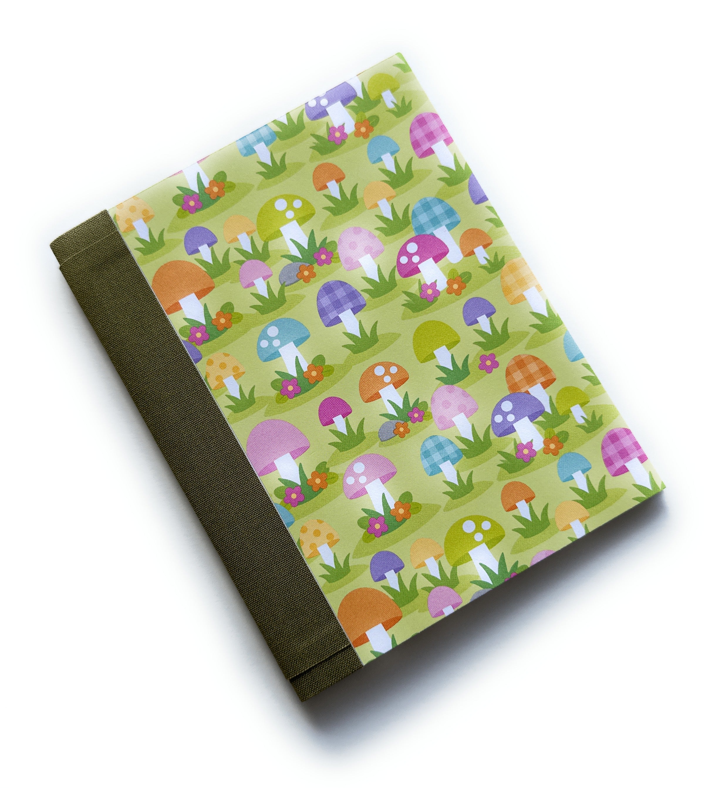 The Merry Mushroom DIY Bookmaking Kit features a whimsical, colorful mushroom pattern on a vibrant green background, accented with playful florals. This handmade bookbinding kit includes all the necessary materials to create a unique journal, perfect for nature lovers, fantasy enthusiasts, and those who appreciate fun, botanical-inspired stationery.