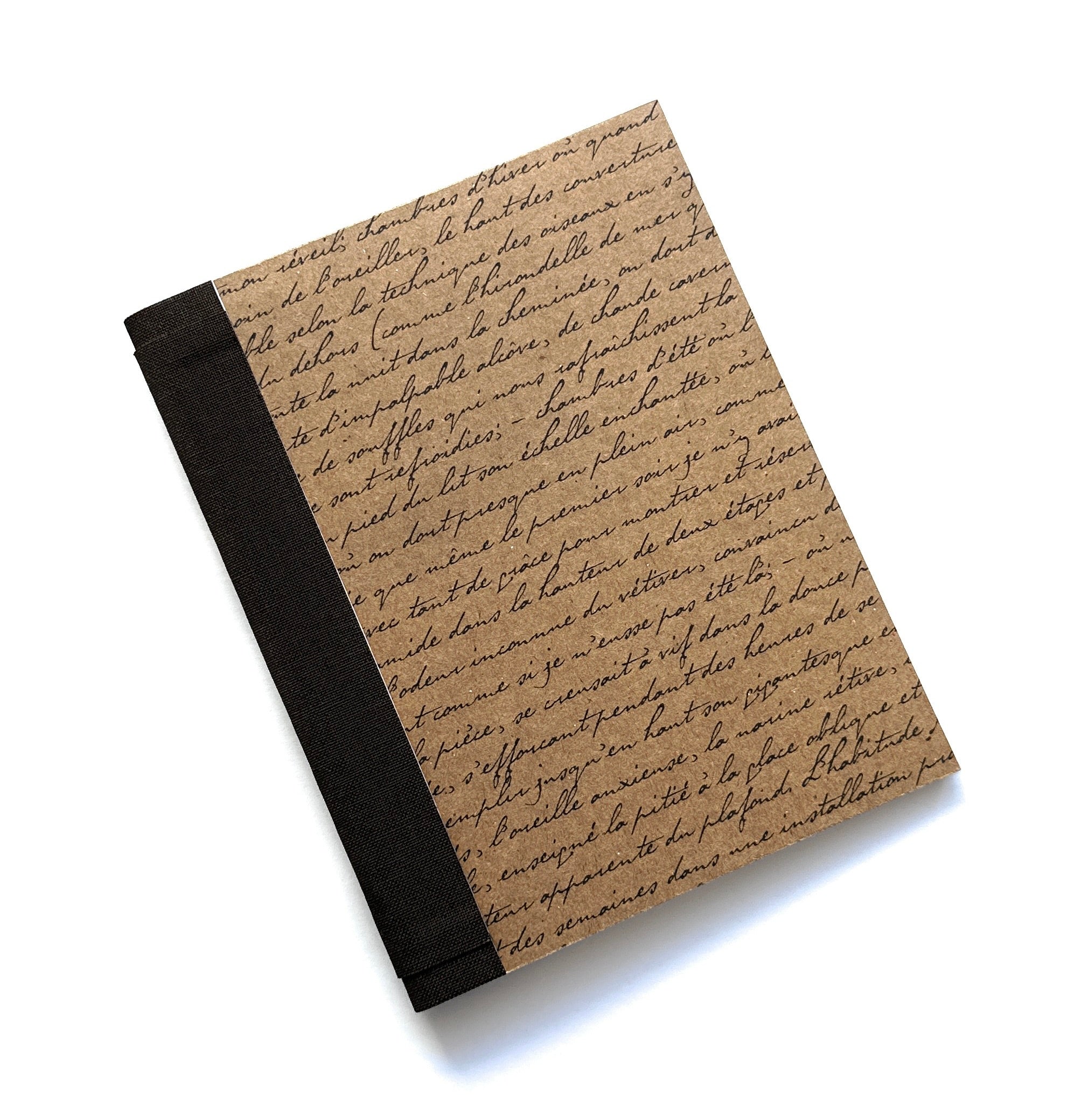 The Storyteller's Bookmaking Kit features a rustic, vintage-inspired cover adorned with elegant handwritten script on textured brown paper. Paired with a classic black book cloth spine, this DIY kit provides everything needed to craft a personalized journal, perfect for writers, artists, and book lovers who want to create a meaningful keepsake.