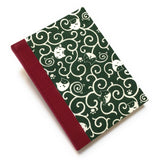 This handcrafted journal features a deep green fabric cover adorned with playful cat illustrations and swirling patterns. Bound with red bookbinding cloth, it is perfect for journaling, sketching, or note-taking, making it a great gift for cat lovers.