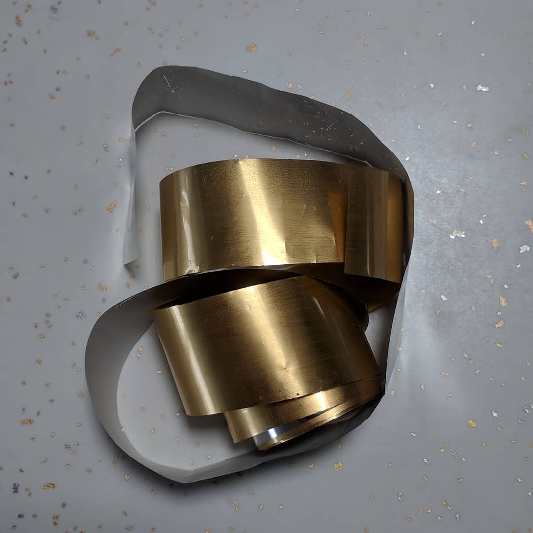 Roll of gold foil on a table with a speckled background
