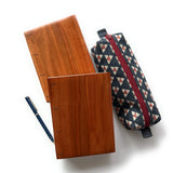 Two handmade Lychee wood Coptic journals with a rich, warm reddish-brown finish and visible Coptic stitch binding, laid flat on a white surface. Accompanied by a blue fabric-covered fountain pen and a geometric-patterned pencil case with a red zipper, this image showcases a stylish and functional stationery set. The smooth wooden covers highlight the natural grain, making these journals perfect for writing, sketching, or journaling with a timeless, artisanal touch.