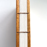 A close-up view of the Mango Wood Coptic Journal, showcasing its exposed spine.  The sturdy wooden covers are paired with durable thread stitching, allowing the journal to lay flat when open. This unique handmade book is perfect for journaling, sketching, or creative writing enthusiasts who appreciate craftsmanship and longevity.