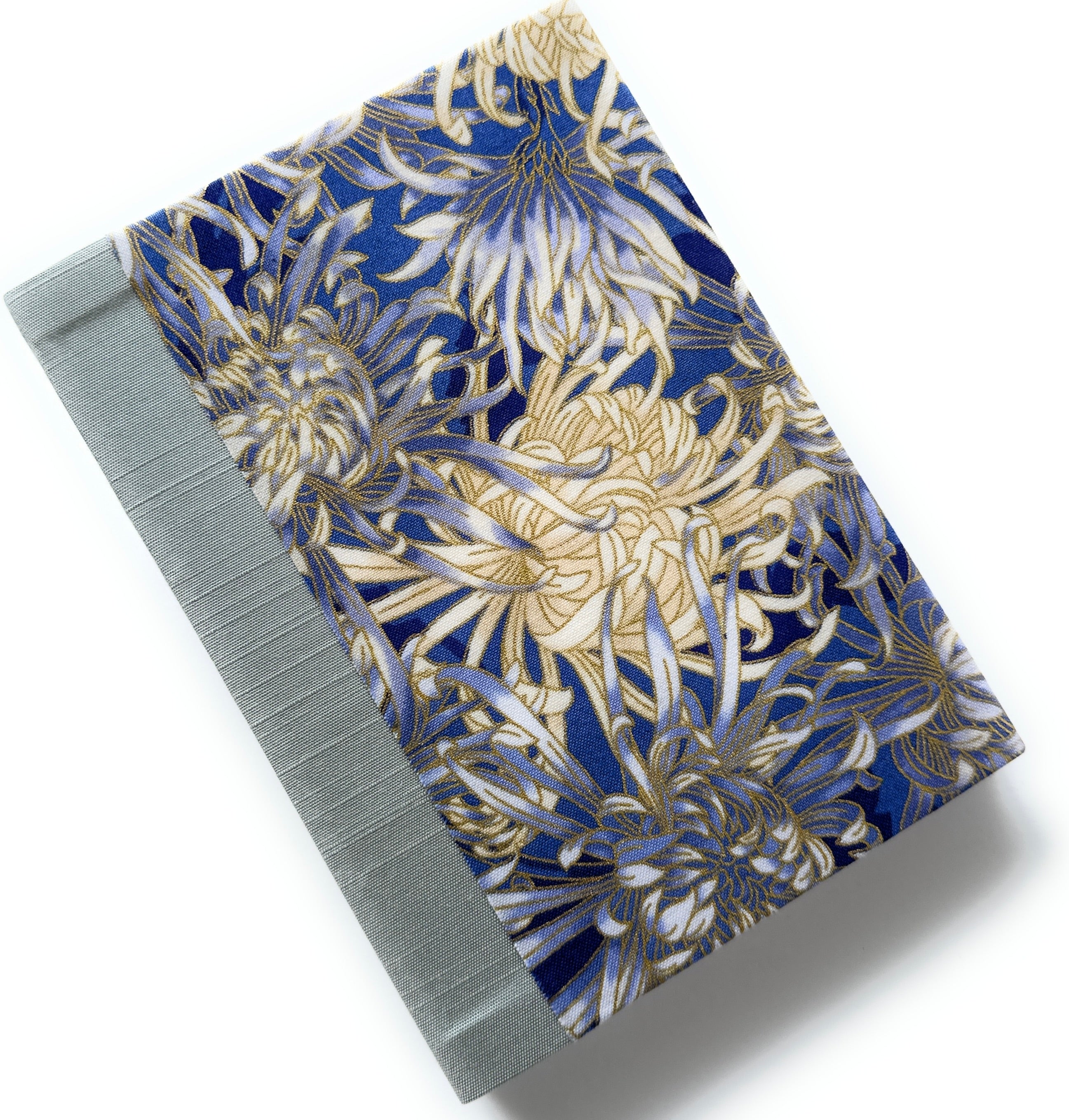 This handcrafted fabric journal showcases an elegant blue and gold chrysanthemum design, accented with a sturdy blue gray book cloth spine. The intricate floral pattern makes this notebook perfect for journaling, sketching, or creative writing. A beautifully crafted gift for writers, artists, and stationery lovers, this Japanese-inspired journal combines functionality with timeless artistry.