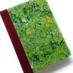 This handcrafted fabric journal features a vibrant green batik cover with intricate abstract patterns, giving it a tropical and artistic appeal. The red book cloth spine provides a striking contrast while ensuring durability. Designed for writers, artists, and journal enthusiasts, this unique handmade notebook is perfect for journaling, sketching, or note-taking.