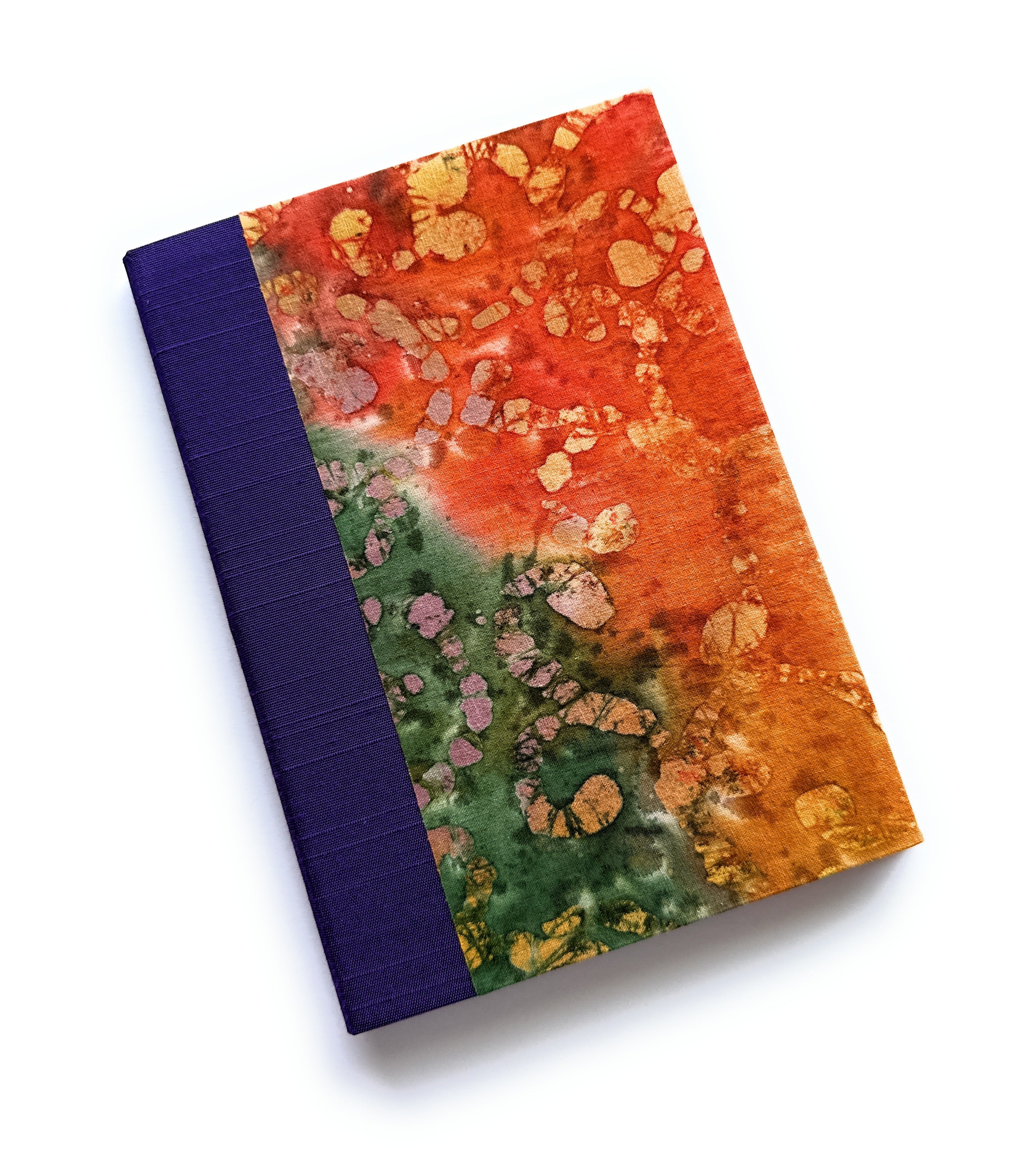 The Chikyū keepsake card showcases a vibrant, earth-inspired design with a rich blend of fiery oranges, deep greens, and golden accents, resembling natural mineral formations. The deep purple book cloth spine adds an elegant contrast, making this a unique and artistic piece for preserving heartfelt messages and special memories.
