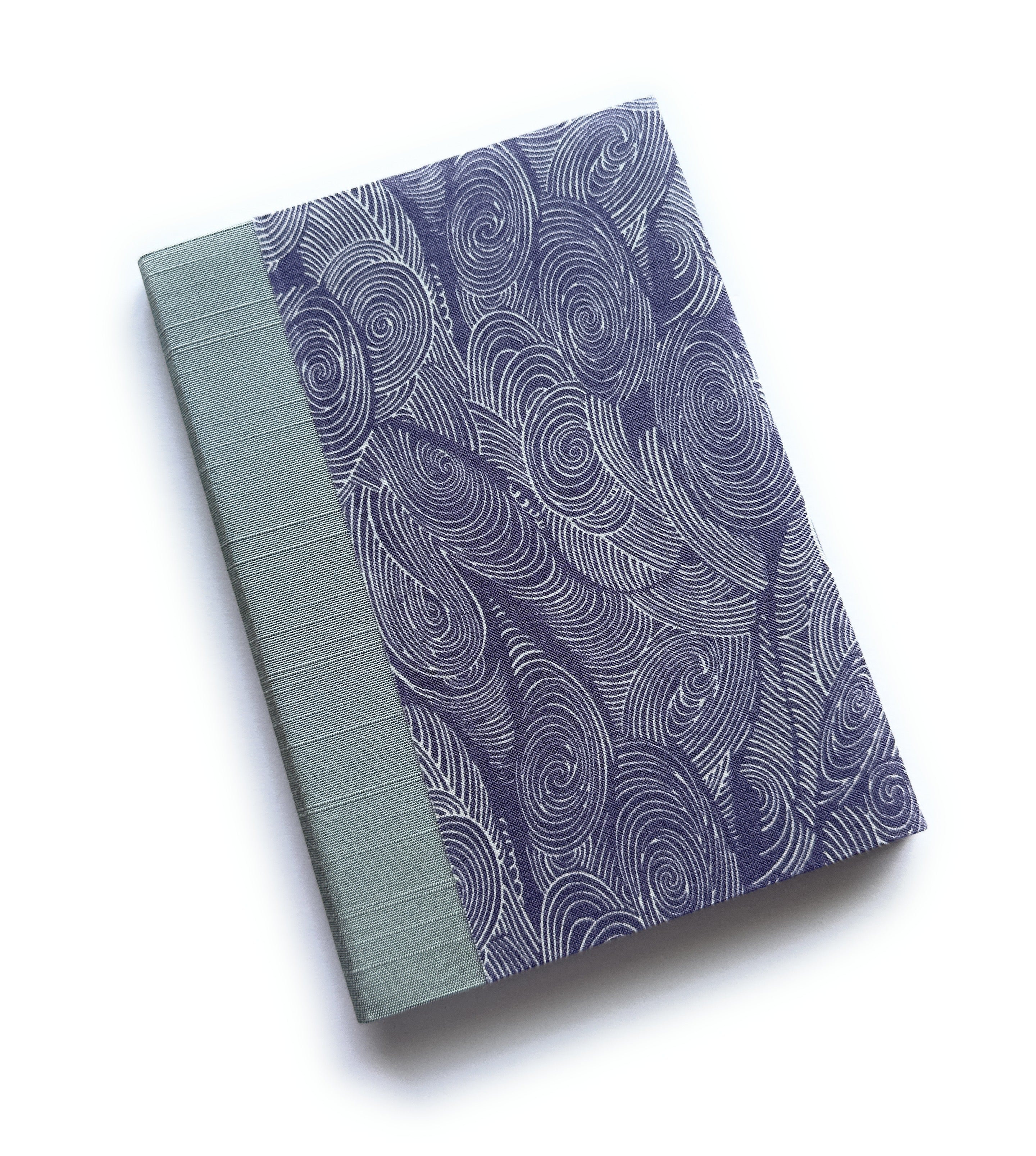 The Uzumaki keepsake card features a mesmerizing deep indigo pattern of swirling waves, inspired by the natural movement of water. Paired with a soft sage green book cloth spine, this handcrafted card is both elegant and serene, making it the perfect choice for preserving heartfelt messages and special memories.