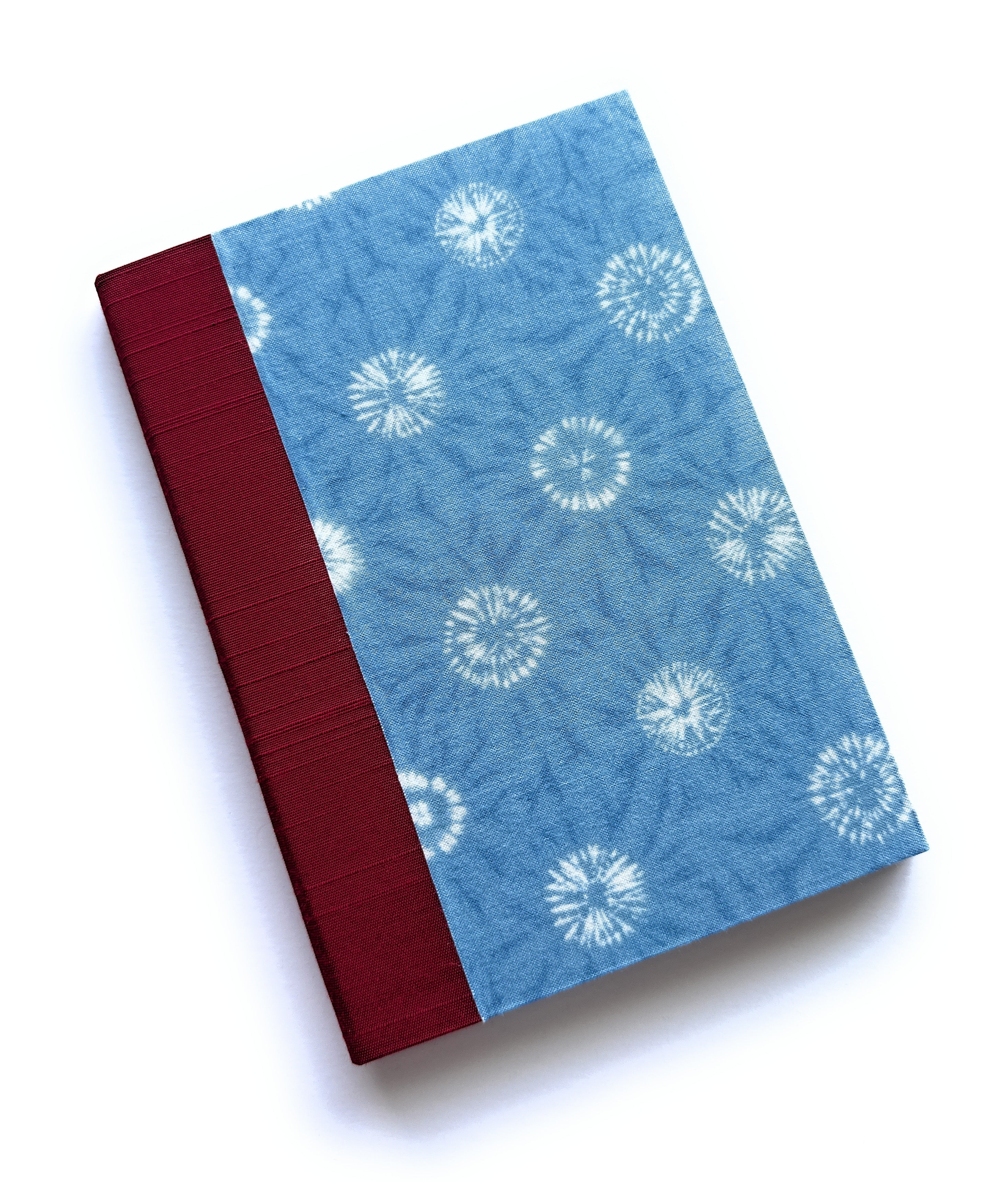 The Yuki keepsake card features a serene blue fabric cover with a delicate shibori-inspired snowflake pattern, complemented by a rich burgundy book cloth spine. Handcrafted for meaningful messages, this unique card is perfect for commemorating special moments, heartfelt sentiments, and cherished memories.