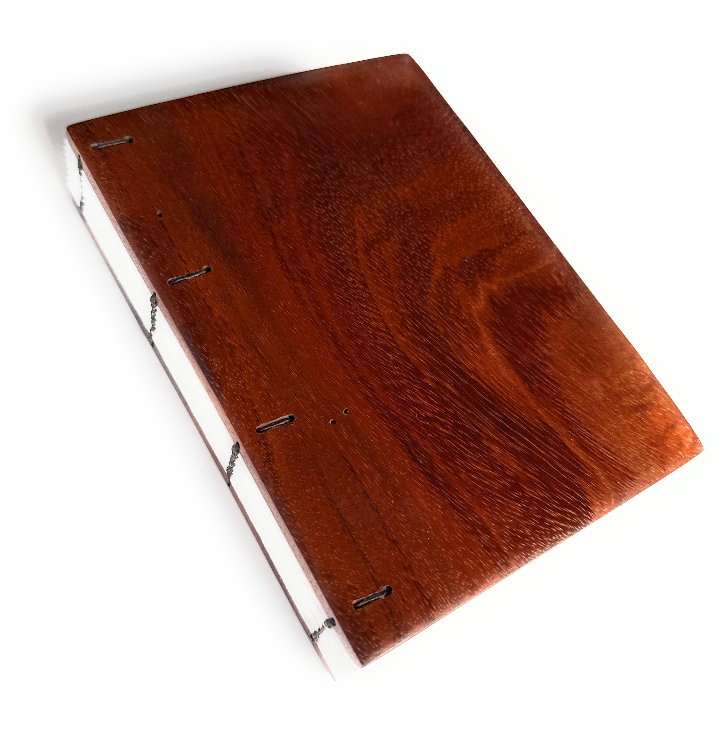 A handcrafted Koa wood Coptic journal featuring a rich, polished wooden cover with visible grain patterns. The exposed spine allows the journal to lay flat when open, making it ideal for writing or sketching.