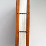 A close-up view of a handmade Lychee wood Coptic journal, showcasing its beautifully exposed Coptic stitch along the spine. The durable wooden covers frame the high-quality, cream-colored pages, bound together with natural waxed thread for flexibility and strength. This binding style allows the journal to lay completely flat, making it ideal for artists, writers, and journal enthusiasts who appreciate traditional bookbinding craftsmanship.