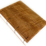 The Mango Wood Coptic Journal features a beautifully handcrafted wooden cover made from rich, warm-toned mango wood, showcasing natural grain patterns. The exposed spine  allows the journal to lay flat when open, making it an excellent choice for writers, artists, and journal enthusiasts seeking a durable, one-of-a-kind notebook.