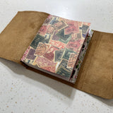 Open notebook with vintage stamp design on a white surface