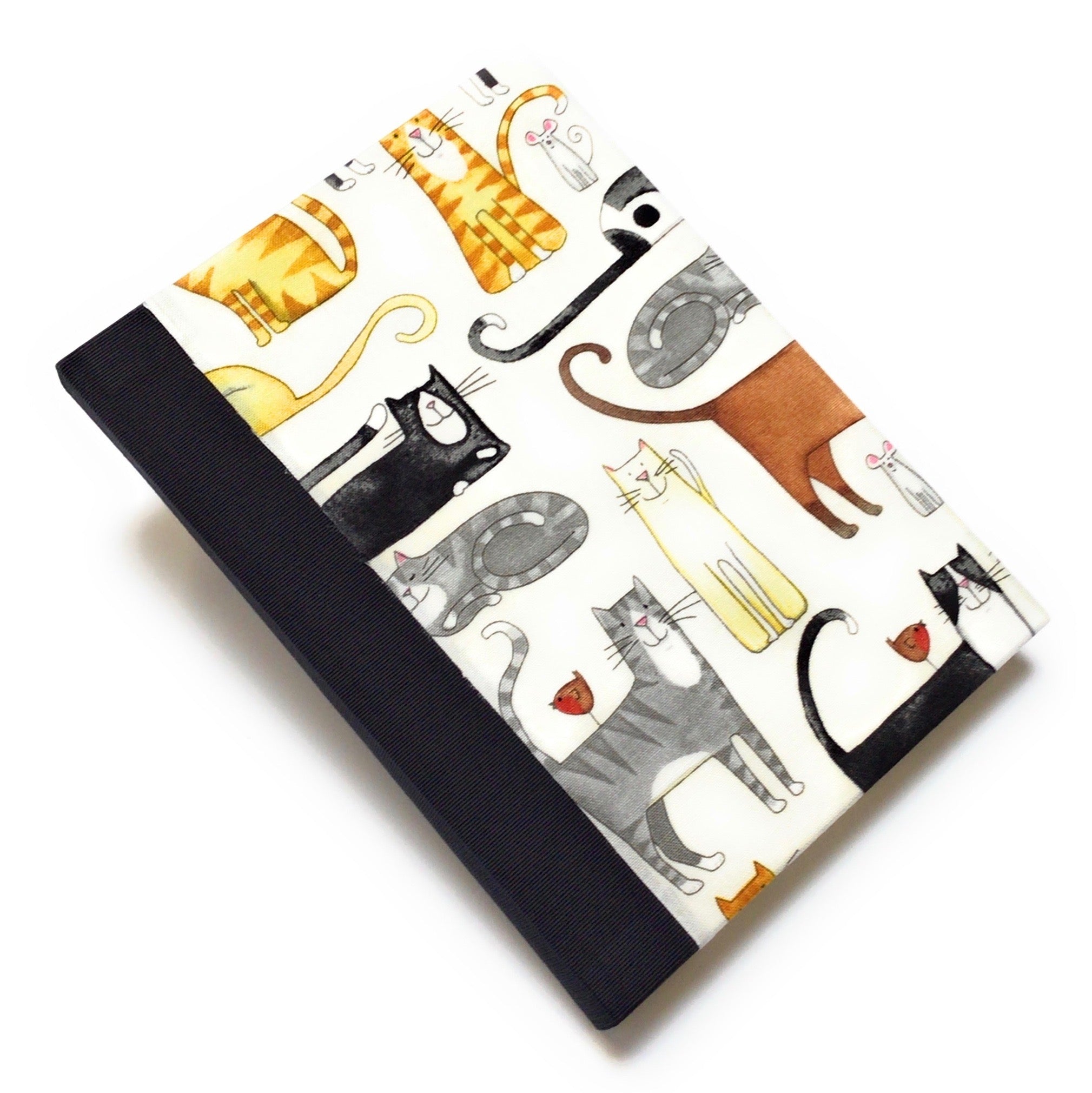 This handmade journal features a delightful fabric cover adorned with playful illustrated cats in various poses, making it a perfect notebook for cat lovers. Bound with a durable black spine and filled with high-quality blank pages, it's an ideal choice for journaling, sketching, or note-taking with a touch of feline charm.