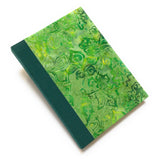 This Aloha Journal features a lush green batik fabric cover with intricate swirling leaf and vine patterns, inspired by nature. Designed with a durable bookbinding cloth spine, this handmade hardcover journal is built for longevity. Inside, premium blank pages provide a smooth surface for writing, sketching, or journaling. Perfect for lovers of botanical stationery, artisan notebooks, or unique handmade gifts.