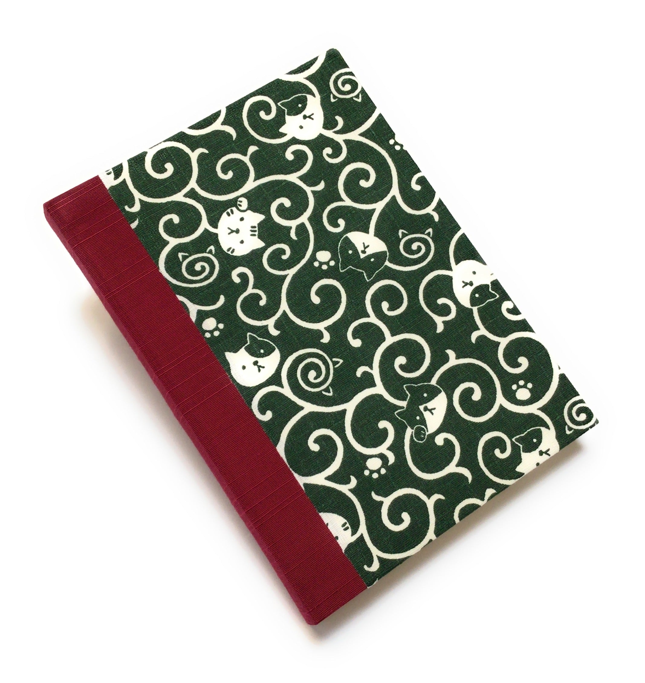 This handcrafted journal features a deep green fabric cover adorned with playful cat illustrations and swirling patterns. Bound with red bookbinding cloth, it is perfect for journaling, sketching, or note-taking, making it a great gift for cat lovers.