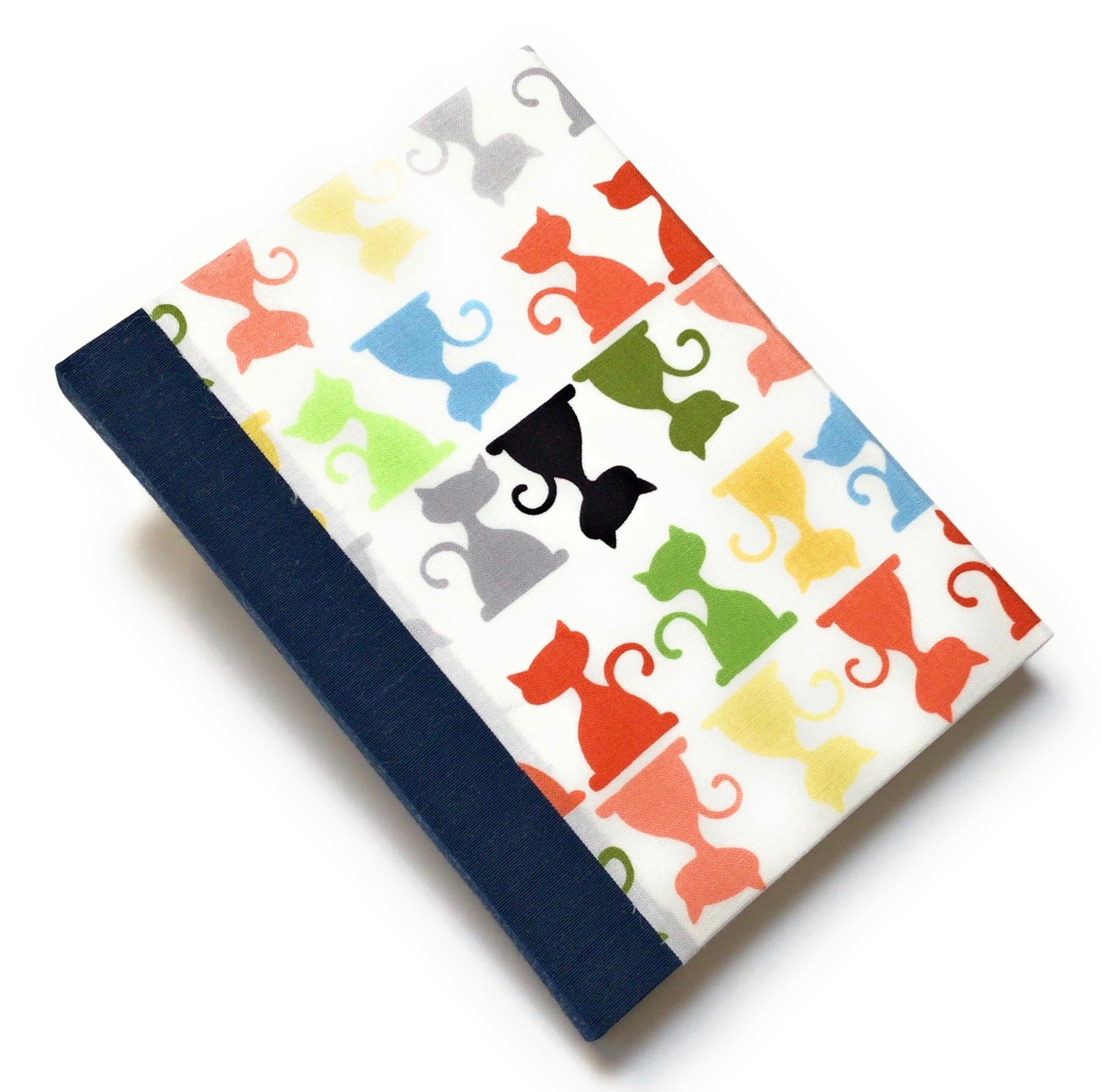 This handcrafted cat journal features a vibrant and playful fabric cover adorned with multicolor feline silhouettes, making it a perfect gift for cat lovers, writers, and artists. Bound with dark blue bookcloth and high-quality materials, this unique notebook is ideal for journaling, sketching, or note-taking.