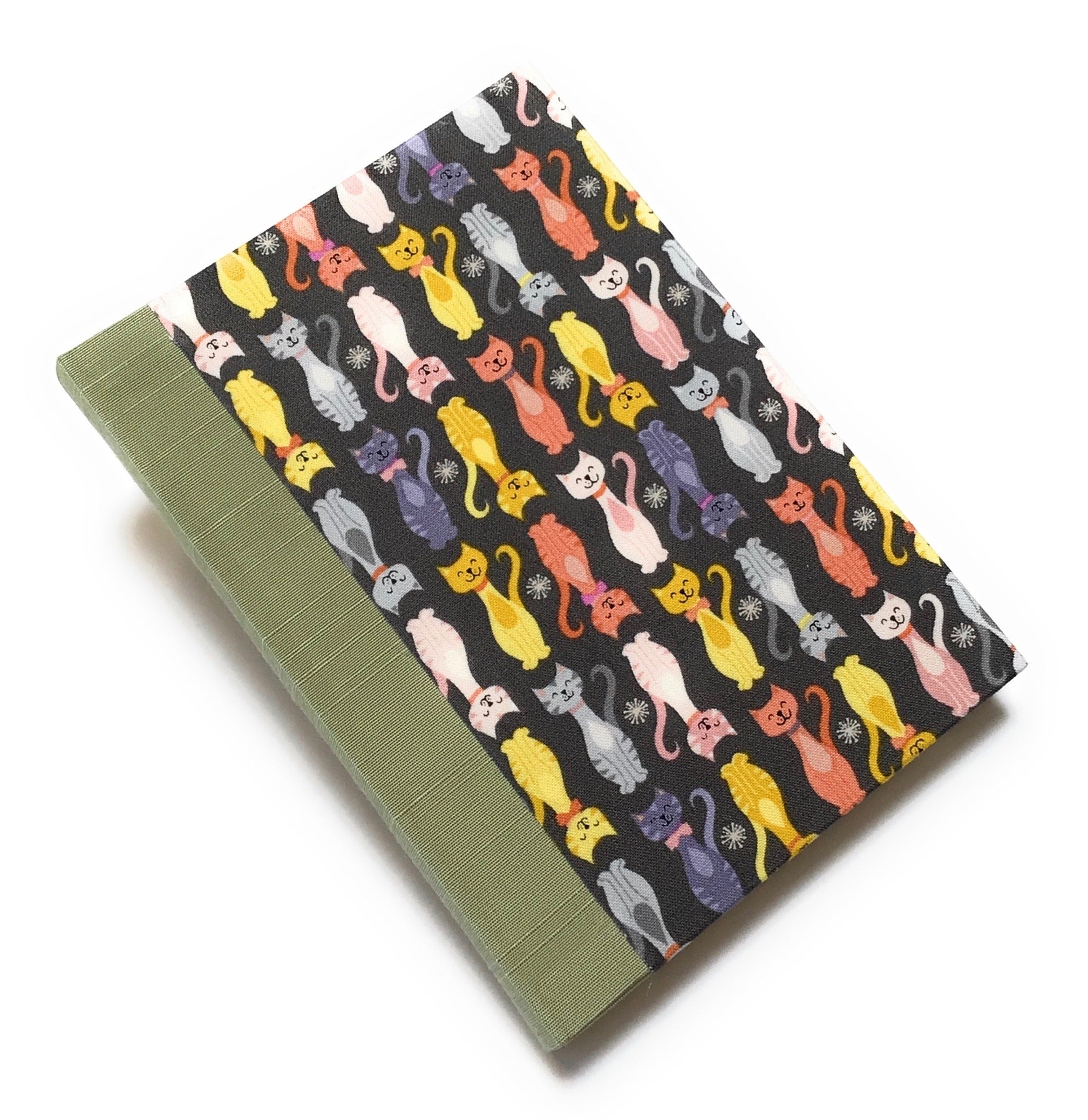 This handmade journal features a charming cat-themed fabric cover with a playful pattern of colorful kittens on a dark background. Designed with high-quality craftsmanship, it’s the perfect notebook for cat lovers, writers, and artists who enjoy capturing their thoughts in a unique and stylish way.