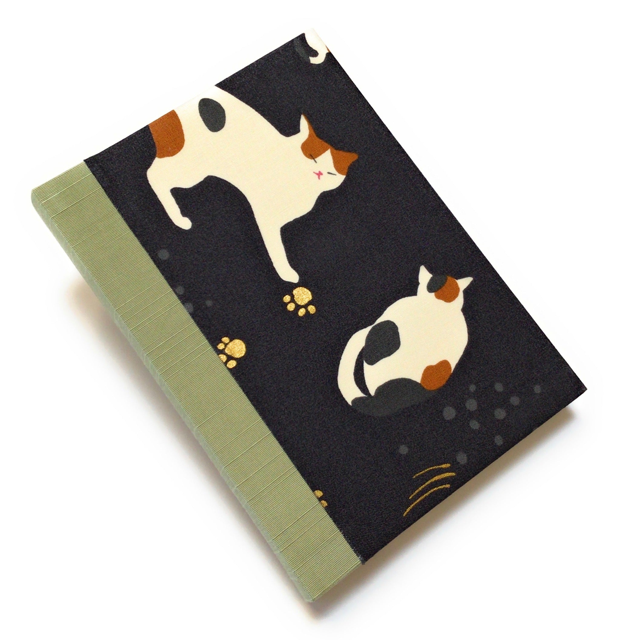 This handmade journal features a black fabric cover adorned with a serene sleeping calico cat design. Bound with a sturdy sage green bookbinding cloth, this notebook is perfect for journaling, sketching, or note-taking.