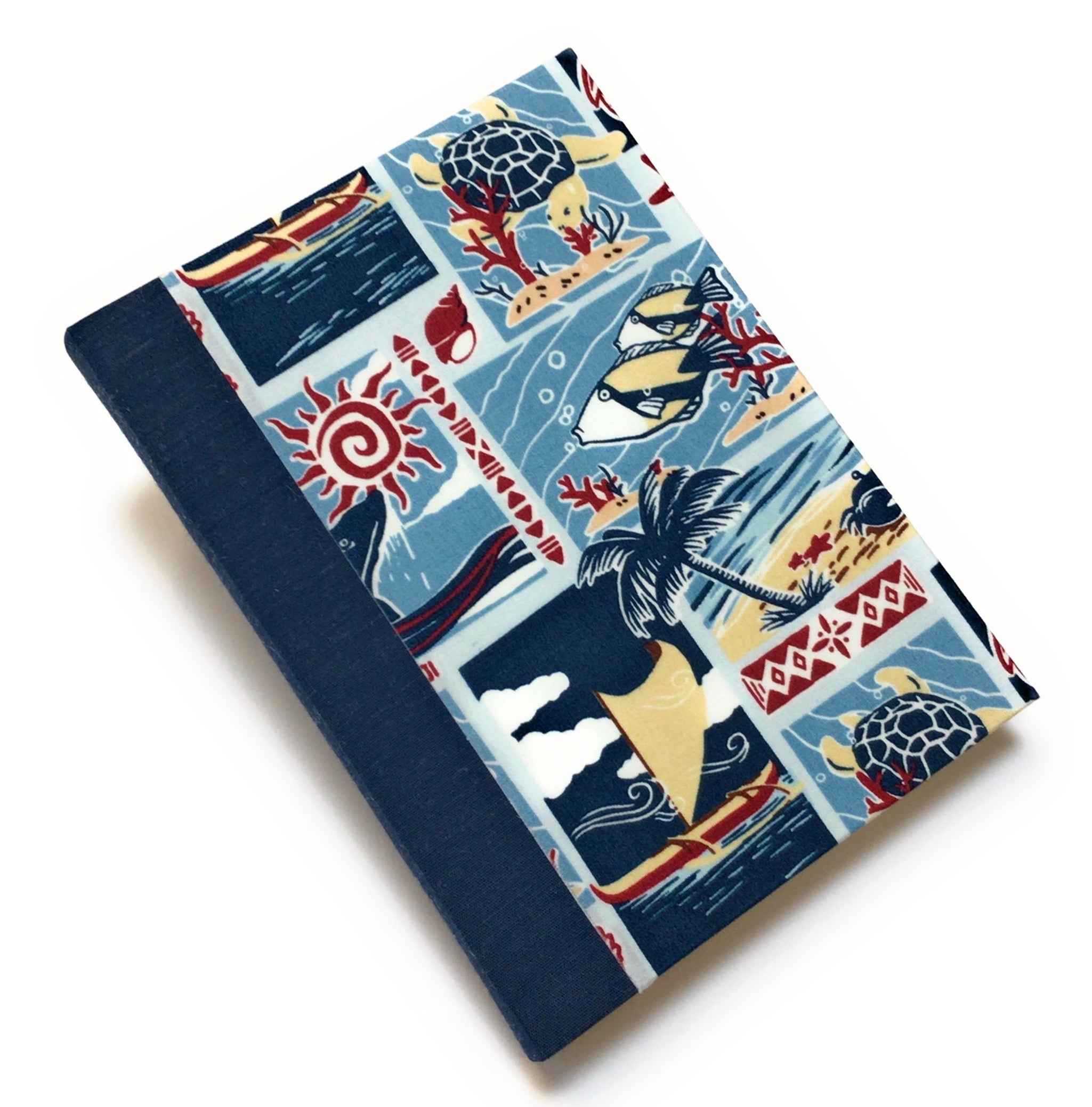 This handcrafted Hawaiian themed journal showcases a vibrant ocean-inspired fabric cover, featuring sea turtles, tropical fish, palm trees, and traditional Polynesian voyaging canoes. The durable bookbinding cloth spine provides added strength, while the interior blank pages offer a versatile space for writing, sketching, or note-taking. Ideal for lovers of Hawaiian stationery, ocean-themed gifts, and handmade notebooks, this island-style journal makes a perfect keepsake or travel companion.