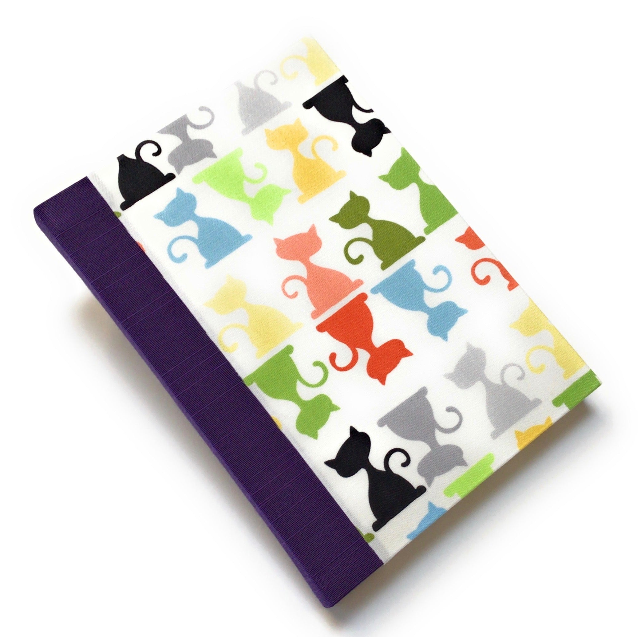 This handcrafted cat journal features a vibrant and playful fabric cover adorned with multicolor feline silhouettes, making it a perfect gift for cat lovers, writers, and artists. Bound with purple bookcloth and high-quality materials, this unique notebook is ideal for journaling, sketching, or note-taking.